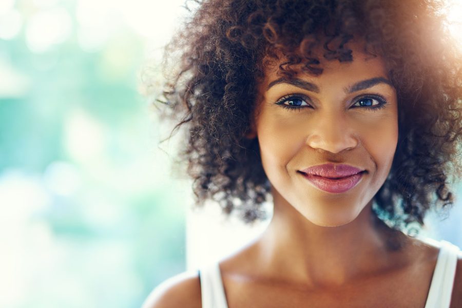 Mulher aparentemente de 35 anos, negra, maquiada e plena