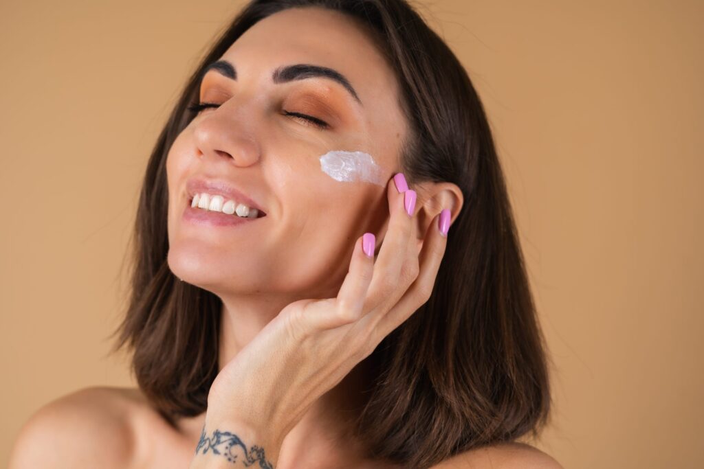 Mulher satisfeita porque está usando primer para preparar sua pele antes da make