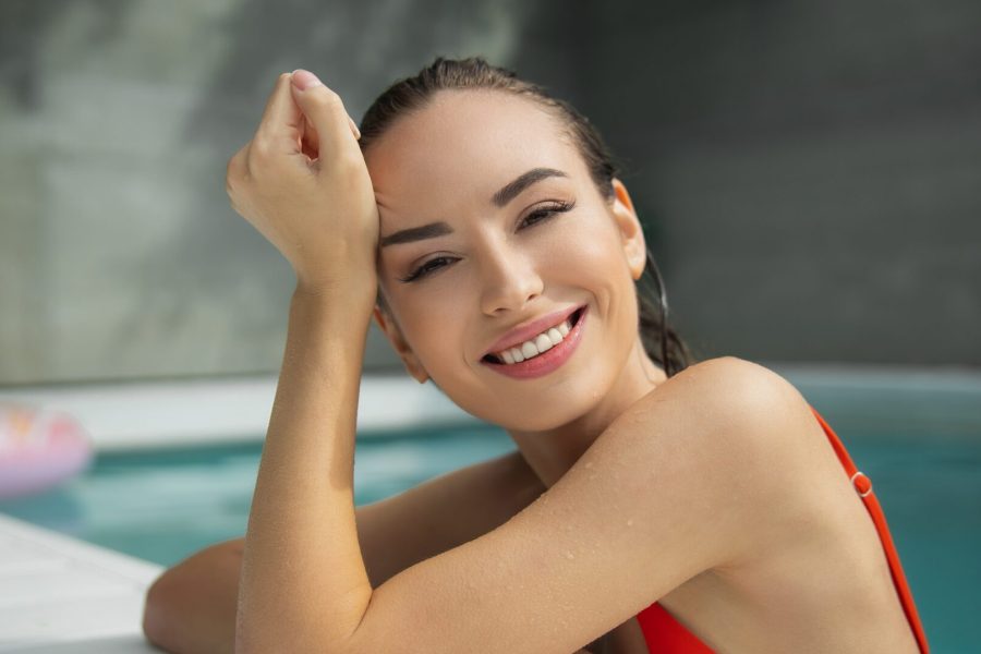 mulher bonita na piscina com a pele bem cuidada